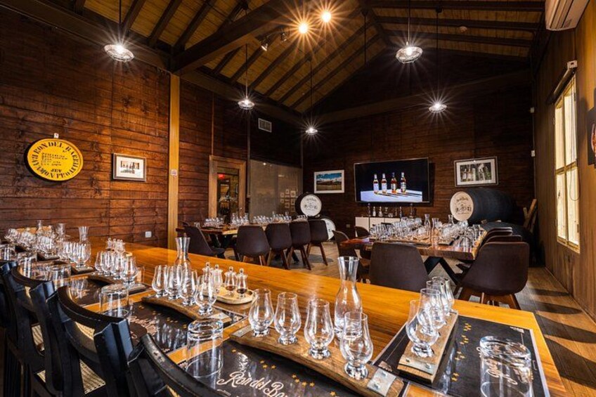 Een rustiek houten interieur met gedekte tafels, een televisiescherm en een bar met flessen. 2