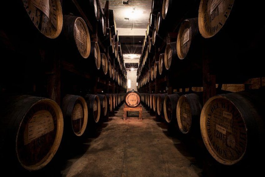 A long corridor lined with wooden barrels, leading to a central wooden bench. 2