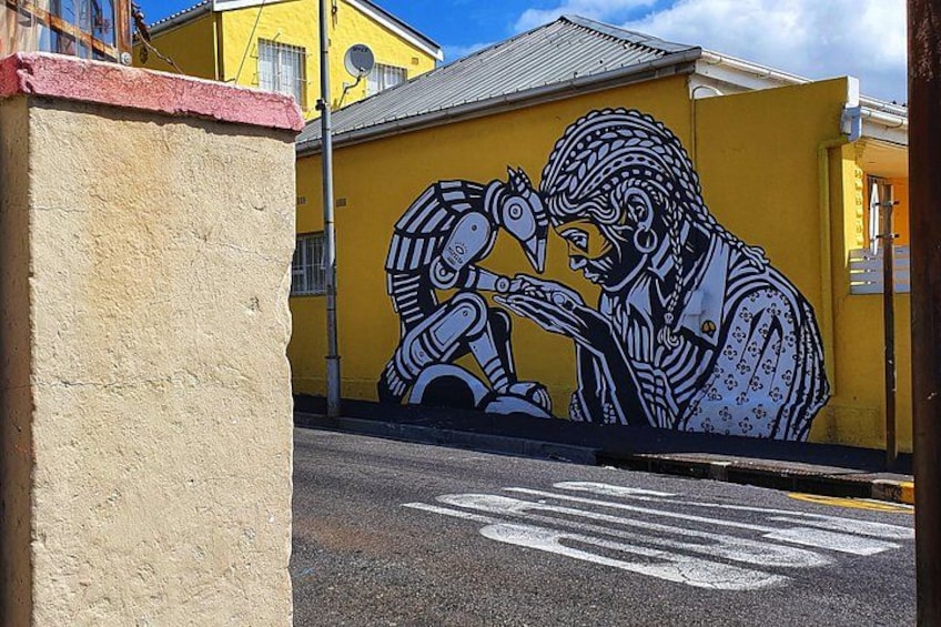 A yellow building with a mural of a person using a telescope. 3