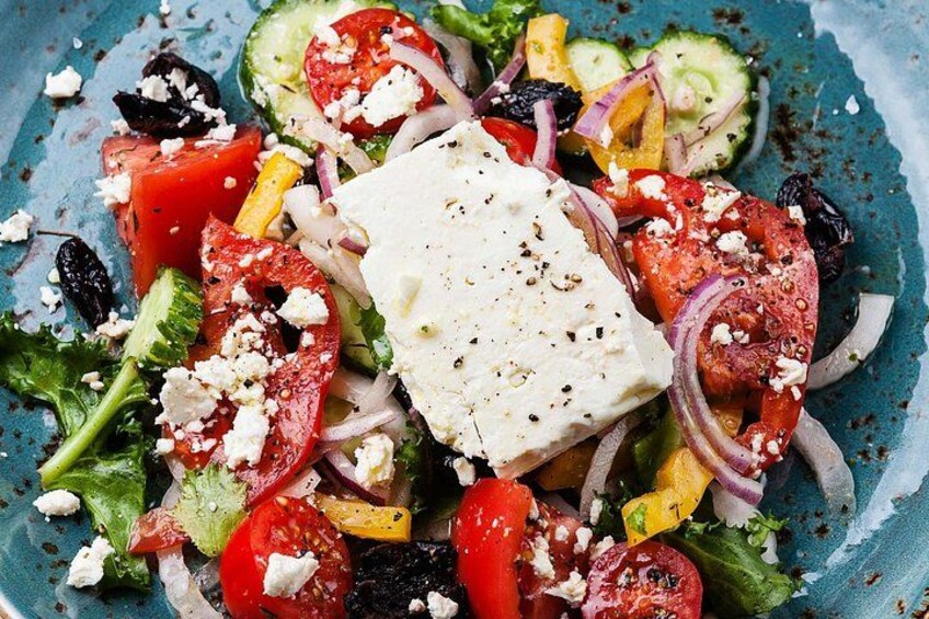 A colorful salad with feta cheese, tomatoes, cucumbers, and red onions. 4