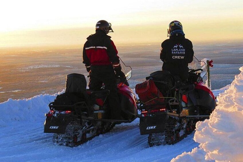 Two snowmobiles on a snowy landscape with a clear sky. 4