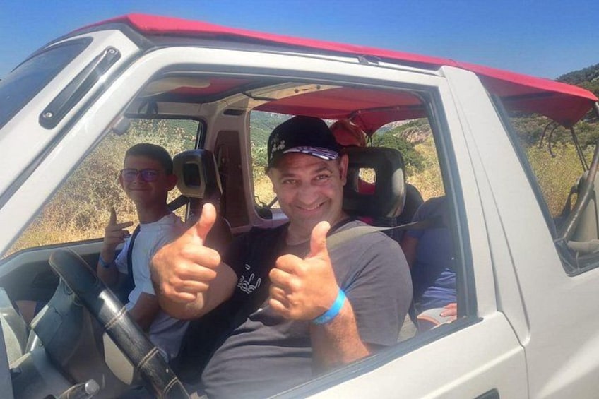 A vehicle with a red canopy, a person giving a thumbs-up, and another person in the background. 4