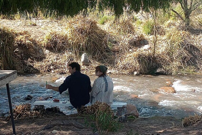 Twee personen bij een rivier met een picknick. 5