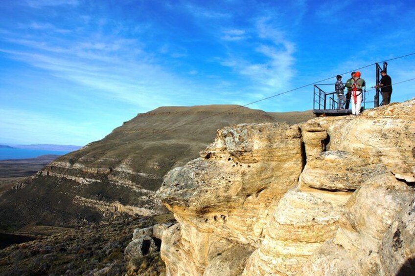 Un acantilado rocoso con personas en una plataforma panorámica. 2