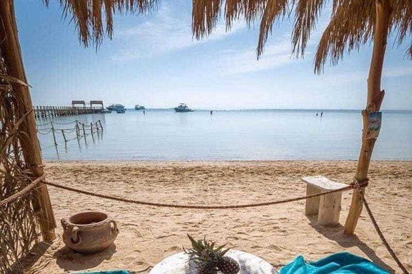 Une plage avec une barrière faite de cordes, un poteau en bois et une coquille de noix de coco. 2