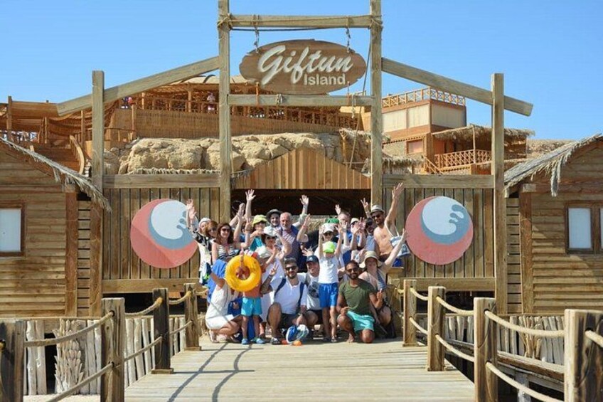 Una pasarela de madera que conduce a un edificio de madera con un letrero que dice 'Giftun Island'. 4