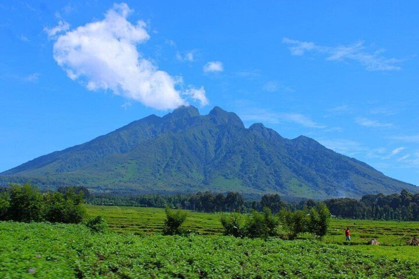 A mountain landscape with a person walking in a field. 4