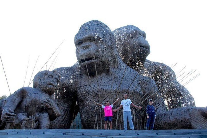 A large sculpture of gorillas with people standing in front of it. 5