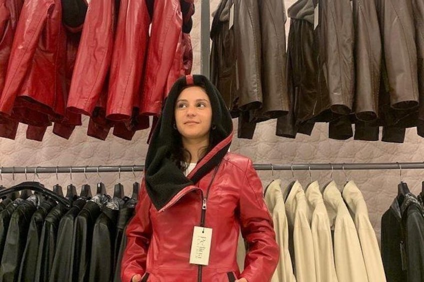 A person standing in a clothing store with various jackets on display. 3
