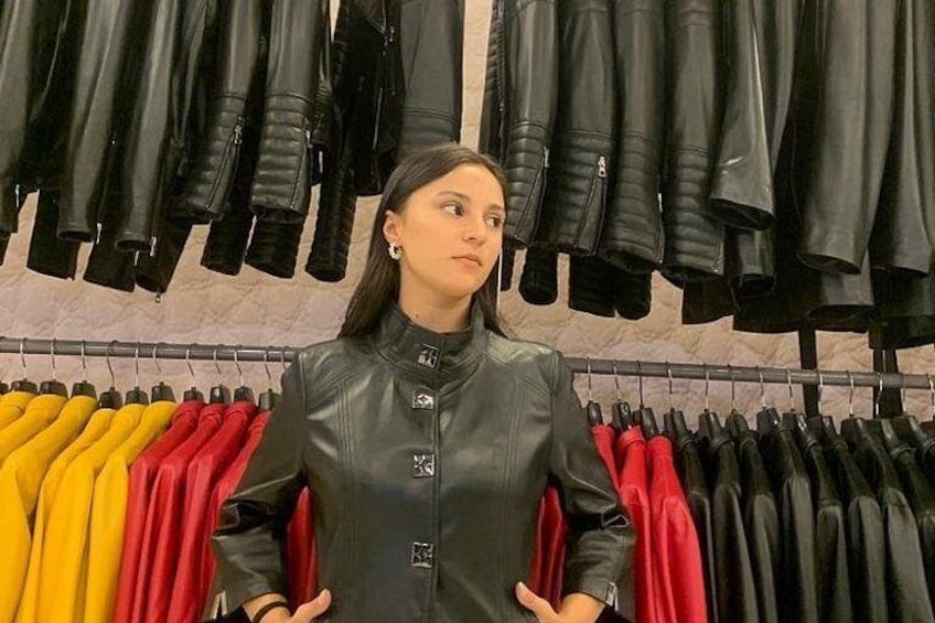 A person standing in a store with leather jackets on display. 2