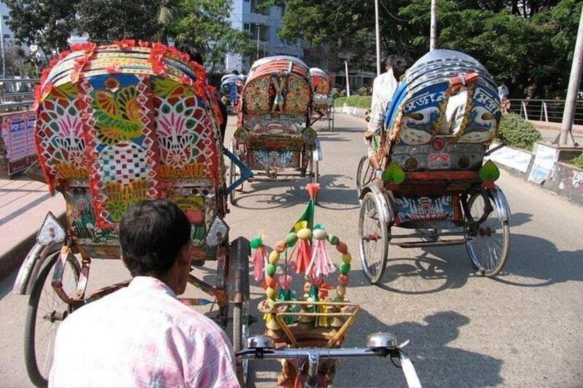 A street with decorated rickshaws and a person riding a bicycle. 3