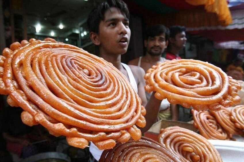 A person holding a large, spiral-shaped sweet. 2
