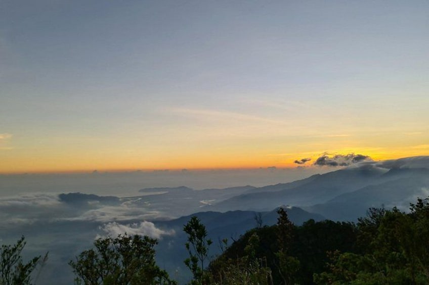 A mountain landscape at sunrise with clouds and trees. 2