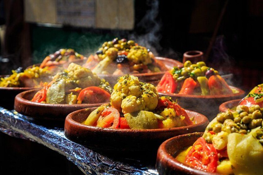 A lot of warm tagines with delicious vegetables on a market 3