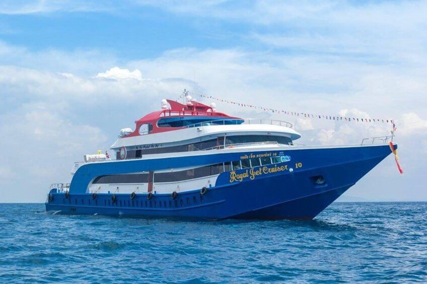 Un yate grande azul y blanco llamado 'Royal Jet Cruiser' con el número 10 en su costado, navegando en el océano. 1
