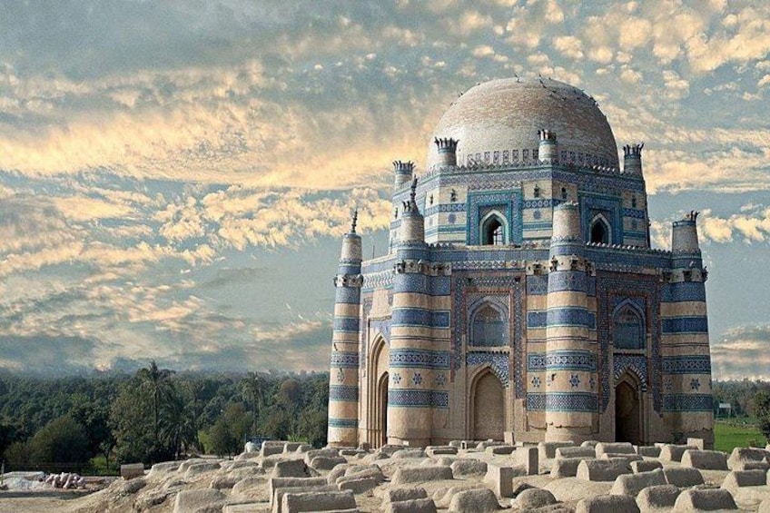 A large, historic building with a dome and multiple minarets, surrounded by ancient ruins. 4