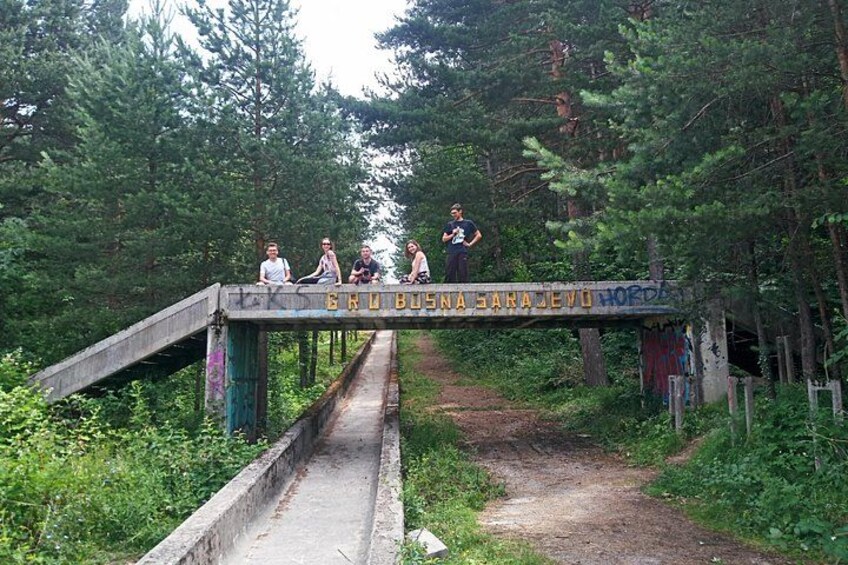 Un puente con grafitis, rodeado de un bosque denso. 4