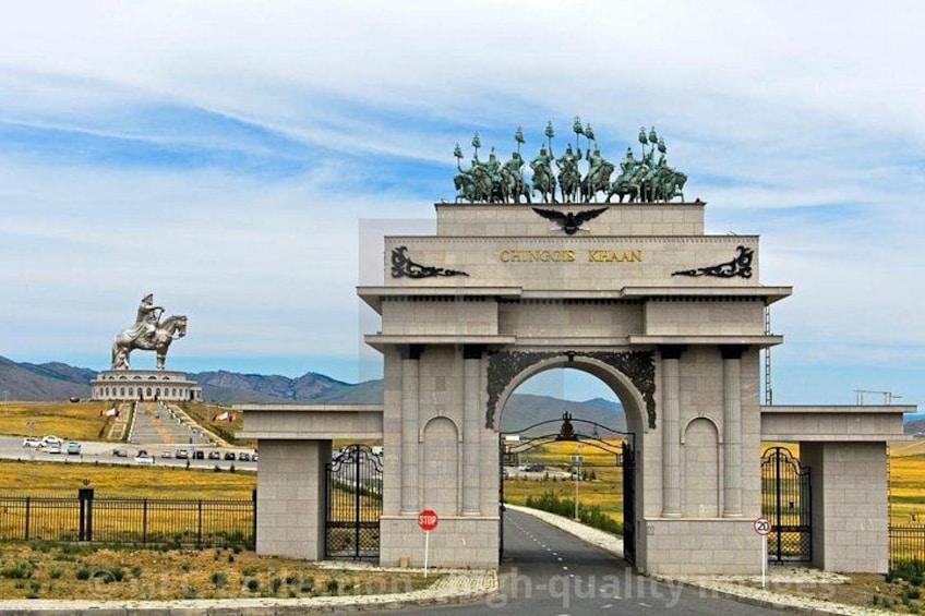 A large archway with inscriptions, a statue of a horse and rider, and a distant monument. 3