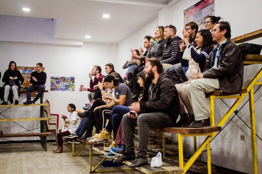 Un grupo de personas sentadas en un espacio interior, posiblemente una conferencia o reunión. 4