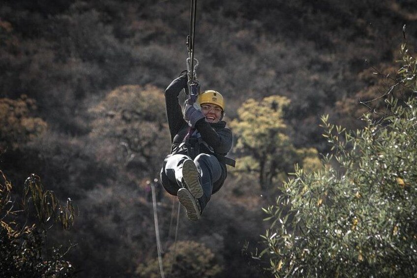 A person zip-lining through a forested area. 2