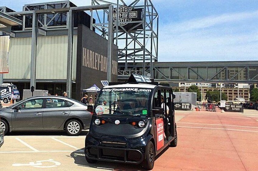 A black vehicle with a Harley-Davidson logo parked in a parking lot. 3