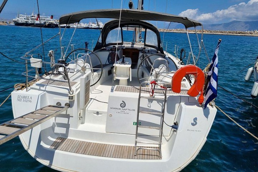 A sailboat named 'IZABELA' docked at a marina with a clear blue sky and calm sea in the background. 2