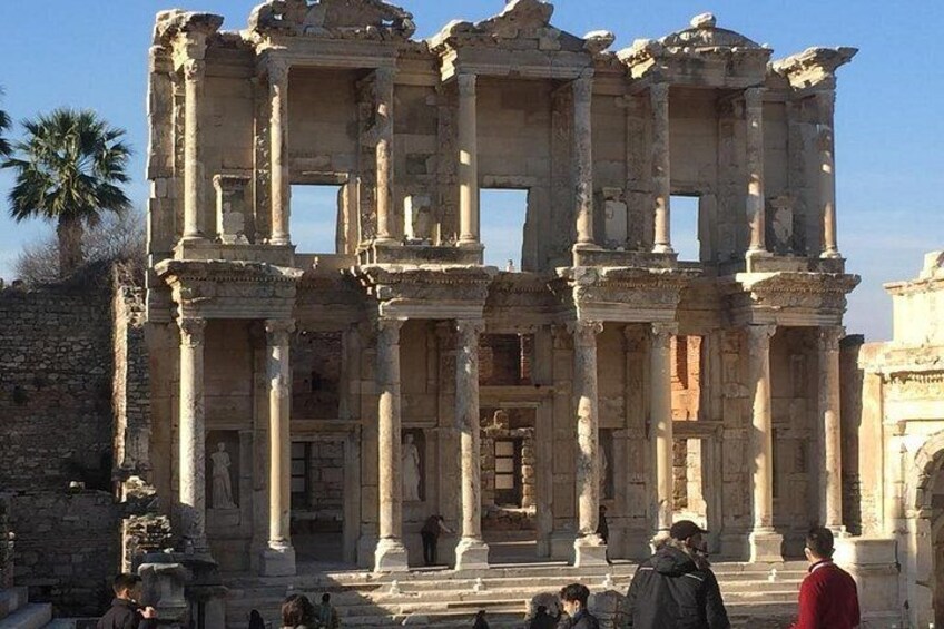 Ancient ruins with columns and arches, surrounded by visitors. 2