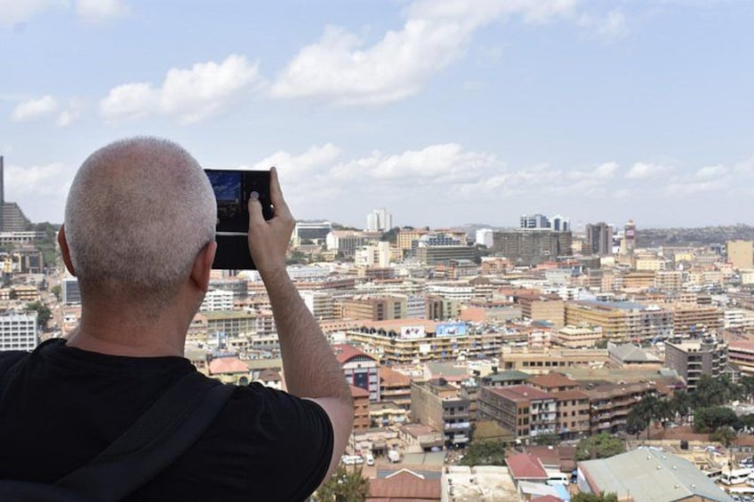 Una persona fotografiando un paisaje urbano con edificios y cielo despejado. 2