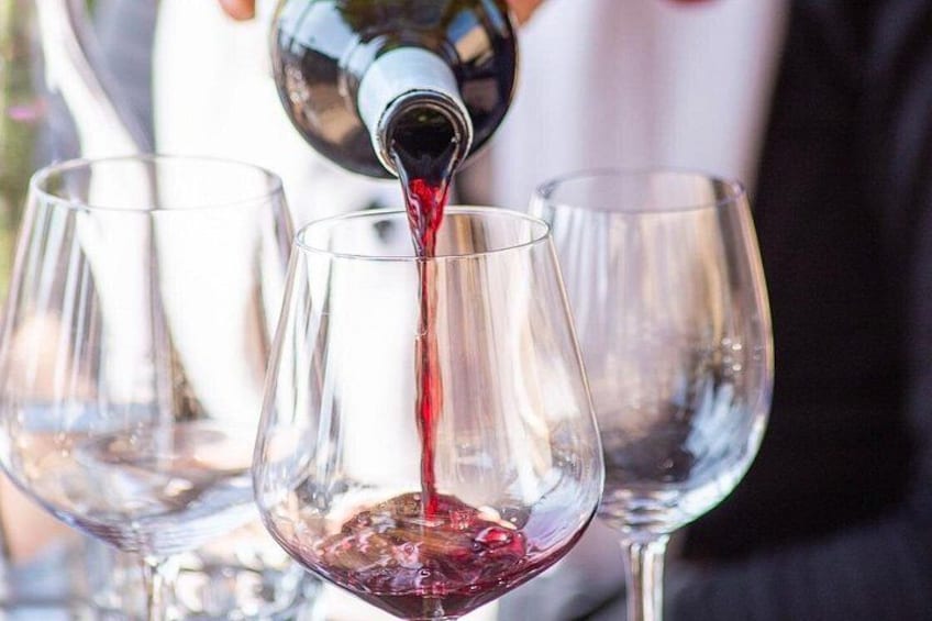 A wine bottle pouring red wine into a glass. 2