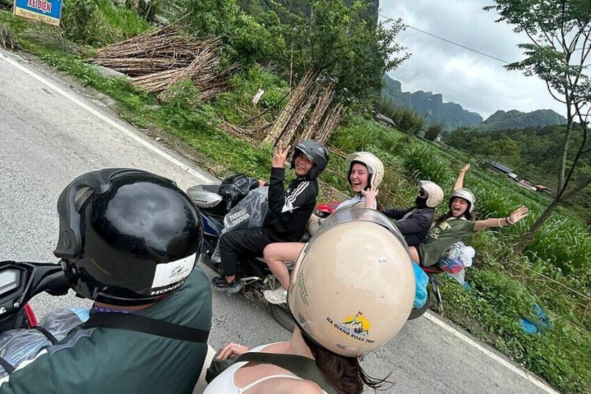 A group of people on a motorcycle, wearing helmets, and one person is holding a large balloon. 4