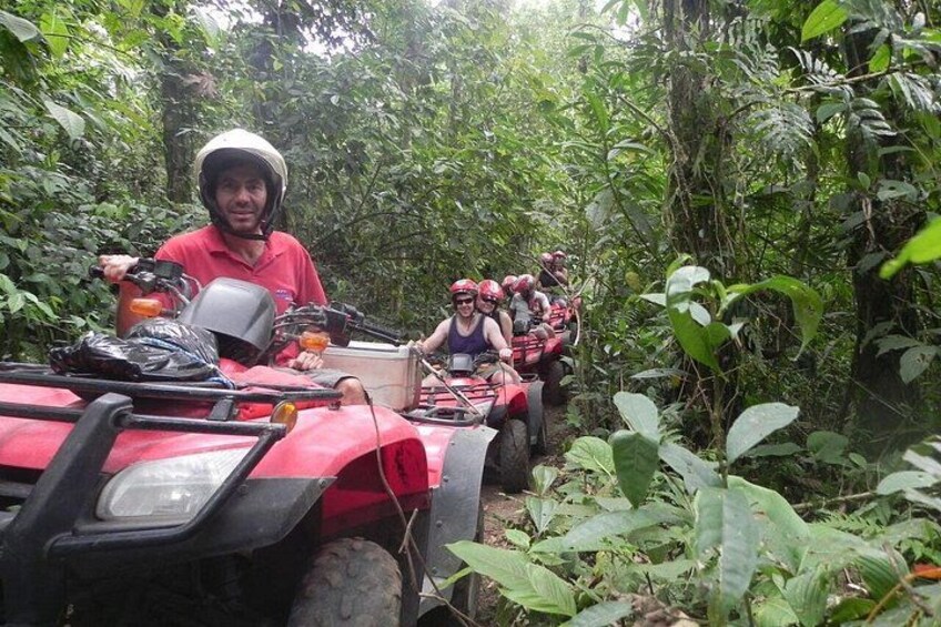 En gruppe mennesker på en rød ATV i et skovområde. 1
