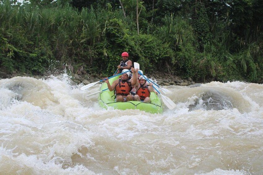A group of people rafting on a river surrounded by dense greenery. 3