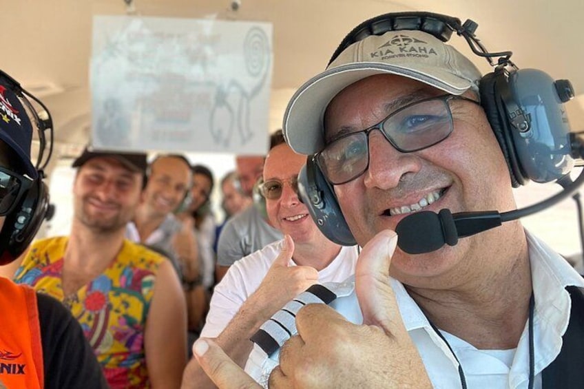 A person wearing a headset and a cap, giving a thumbs-up gesture. 1
