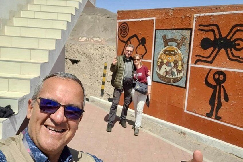 En person som tar en selfie med en pyramid i bakgrunden och en väggmålning synlig. 3