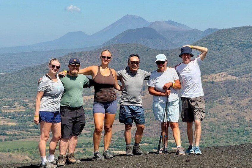A group of people standing on a mountain ridge with a view of a mountain range in the background. 3