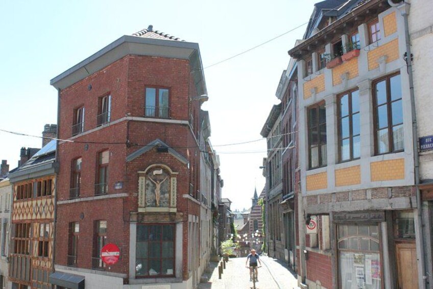 Une rue étroite, bordée de bâtiments des deux côtés, un cycliste au loin et, à gauche, un panneau rouge indiquant qu'il est interdit d'y entrer. 5