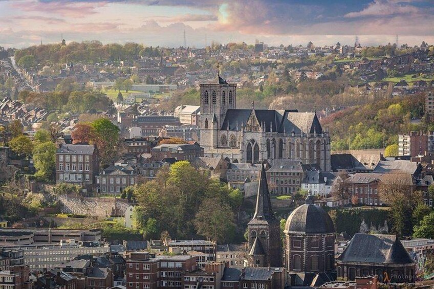 A cathedral with a tall spire, surrounded by historic buildings and a cityscape in the background. 3