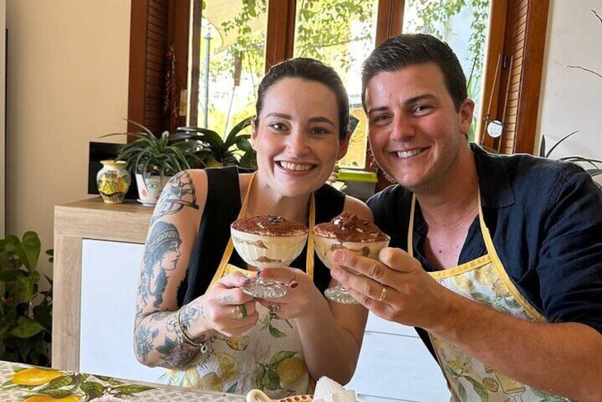 Dos personas sosteniendo vasos de postre en una mesa con una ventana al fondo. 2