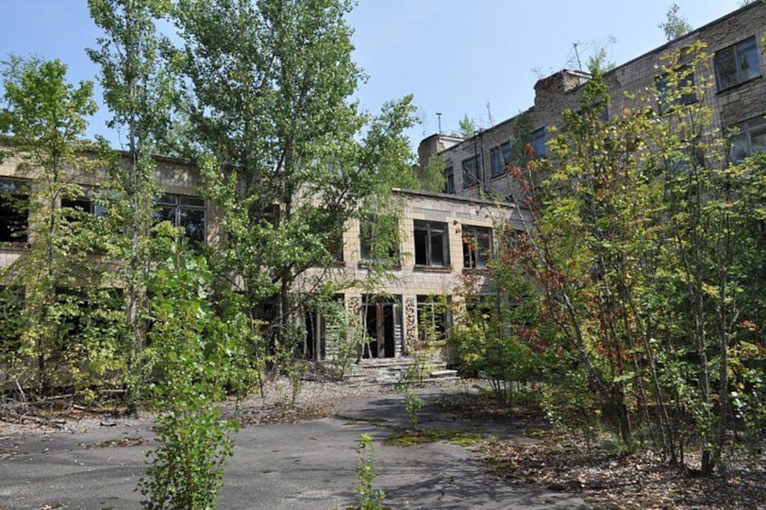 A building with a brick facade, surrounded by trees and a paved area. 4