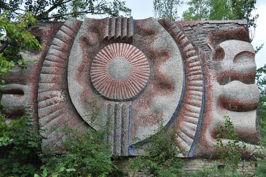 A large, weathered stone sculpture with a circular pattern and animal figures. 2
