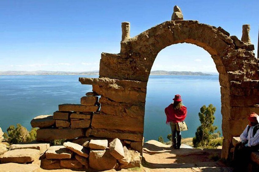Un antico arco in pietra con vista su uno specchio d'acqua. 3