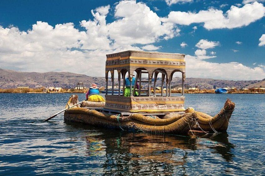 A traditional boat with a covered structure on a body of water, surrounded by a mountainous landscape. 5