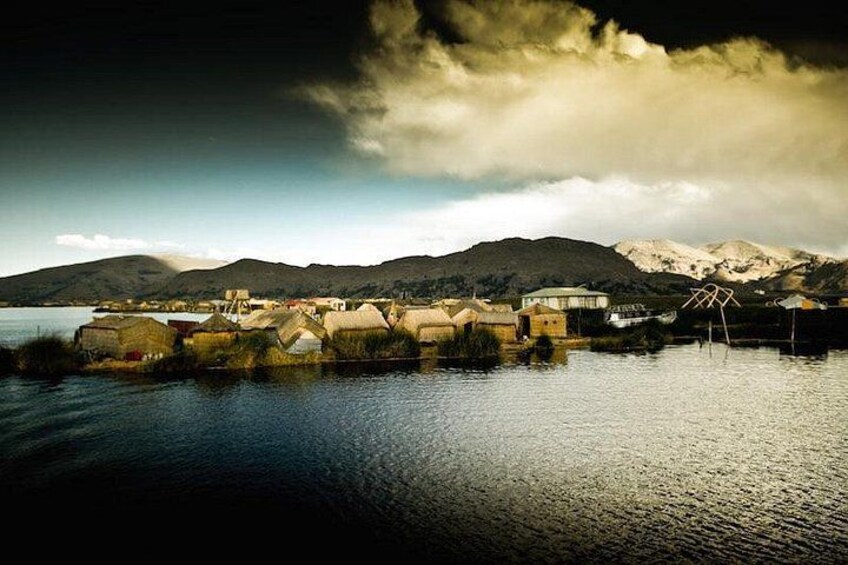 A lakeside village with houses and a mountain backdrop. 3