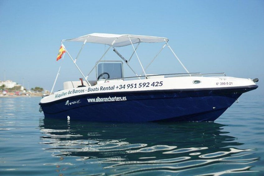 A blue boat with a canopy, registration number, and website on its side. 1