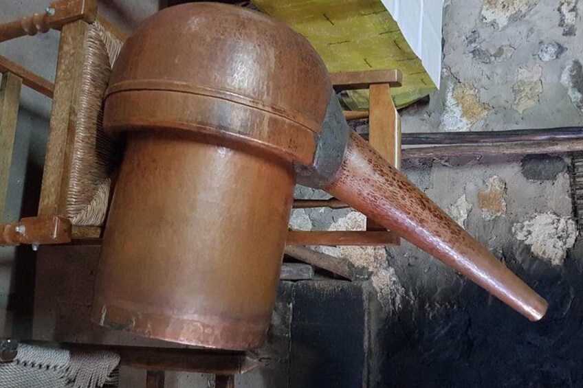 Una olla de cobre con un asa larga, sobre una superficie de madera. 3