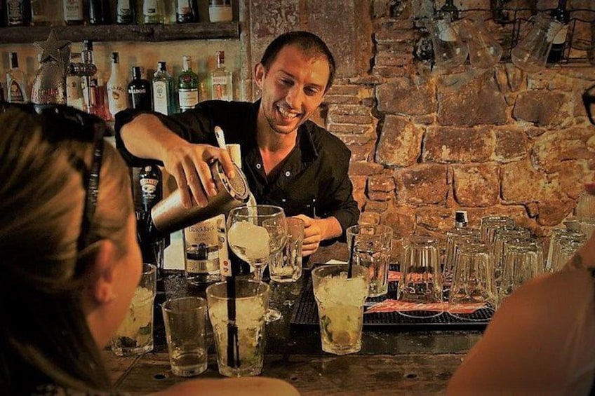 En bartender som häller upp en drink i ett glas. 5