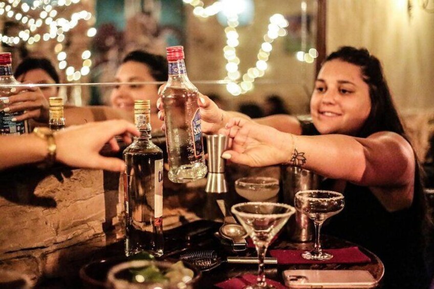 En grupp människor som skålar med drinkar på en bar. 1