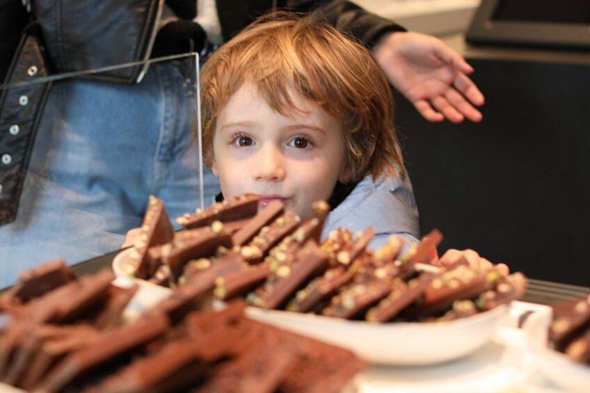A child reaching out towards a plate of brownies. 2