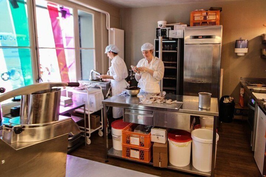 Cocina profesional con electrodomésticos de acero inoxidable, un refrigerador grande y dos chefs trabajando. 3