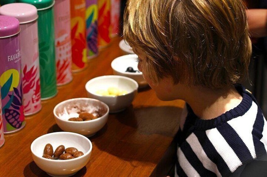 Niño sentado a una mesa con cuencos de comida y latas de bebida de colores. 4